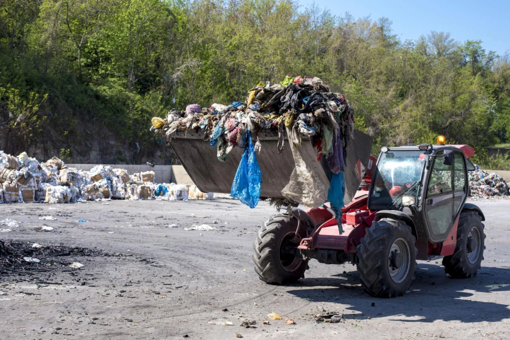 American Vet Solutions heavy equipment removing landfill waste during large-scale environmental cleanup and waste management operations